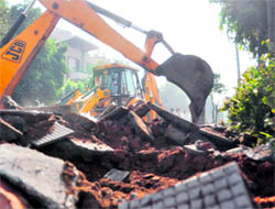 A JCB machine demolishes an illegal structure in BRS Nagar, Ludhiana, on Tuesday