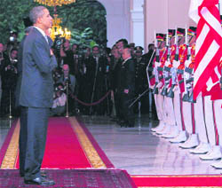 US President Barack Obama accompanied by his Indonesian counterpart Susilo B Yudhoyono listens to the national anthem during a welcoming ceremony at Merdeka Palace in Jakarta on Tuesday.