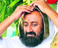 Sri Sri Ravi Shankar adjusts his head cloth at a congregation in Jarkhar village near Ludhiana on Wednesday