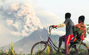 Boys watch Mt Merapi erupt again in Indonesias Manisrengoo village on Wednesday.