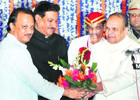 Maharashtra Governor K Shankaranarayanan greets newly sworn in Chief Minister Prithviraj Chavan and Deputy Chief Minister Ajit Pawar at the Raj Bhavan in Mumbai