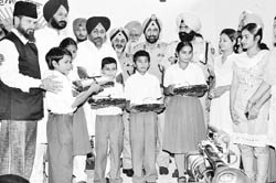 Deputy Chief Minister Sukhbir Singh Badal distributes school dresses among children at Police DAV School in Sangrur