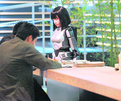 Delegates enjoy traditional Japanese tea at a served by a robot at the "Japan Experience: Ideas Into Reality" exhibit on the sidelines of the Asia-Pacific Economic Cooperation (APEC) forum summit meeting in Yokohama on November 11, 2010.