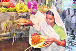 Devotees performing Chhat Puja at Raipur Canal in Dehradun; and (right) at Har-ki-Pauri in Haridwar on Friday