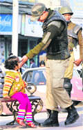 A CRPF jawan plays with a child at Lal Chowk in Srinagar
