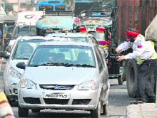 A traffic cop directs a car driver to speed up at Bhai Bala Chowk in Ludhiana.