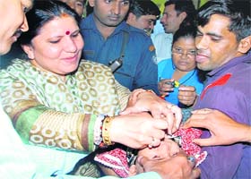 Education Minister Geeta Bhukkal administers polio drops to a baby to launch a campaign against polio in Jhajjar