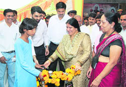 Haryana Health Minister Geeta Bhukkal gives a bicycle to a girl student during a programme at Panchayat Bhawan in Jhajjar.