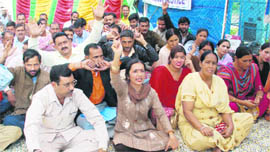 Members of the All-J&K Home Guard Volunteers Association hold a demonstration in front of the Divisional Commissioners office in Jammu on Monday.