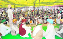 Farmers and farm workers stage a dharna outside the DCs office at Mansa on Monday.