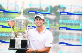 Adam Scott of Australia poses with his trophy after winning the Singapore Barclays Open golf tournament
