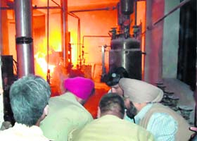 Firemen try to douse flames at Anuja Healthcare Limited in Mubarkpur near Dera Bassi in which four workers were injured on Tuesday evening