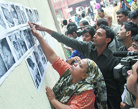 People go through the photographs of the unidentified victims at the Lok Nayak Jai Prakash Hospital in New Delhi on Tuesday.
