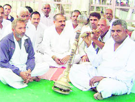 Farmers enjoy puffs of hookah during a dharna at Gorakhpur in Fatehabad. 