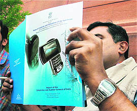 A journalist reads a copy of the CAG report