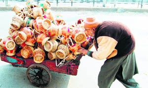 An old Kashmiri sells traditional firepots, known as kangris, on a hand cart in Srinagar.