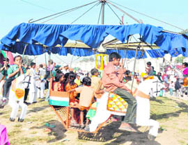 Children enjoy a ride at eidgah ground in Jwalapur, Haridwar, on Wednesday. 
