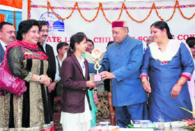 CM Prem Kumar Dhumal gives prize to a winner on the concluding day of the 18th Children Science Congress at Hamirpur on Wednesday.