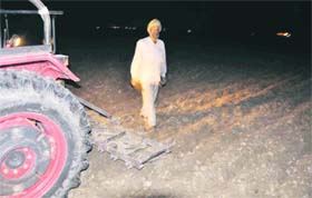 A farmer ploughs his fields at night as the detonation exercise is not allowing them to do so during day time