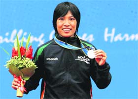 India's Wangkhem Sandhyarani shows her silver medal that she won in the women's Sanshou 60kg wushu final in Guangzhou
