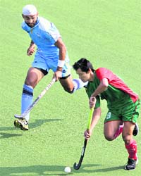 India's Sandeep Singh and Bangladesh's Pushkor Khisa vie for the ball in Guangzhou