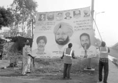Employees of the GMR company remove hoardings in Zirakpur on Thursday.