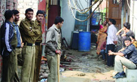 Delhi police personnel outside the burnt house following a fire at Mohan Garden in west Delhi on Thursday.