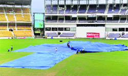 Groundsmen cover the pitch at VCA Stadium after heavy rains in Nagpur on Thursday. Inclement weather is threatening to seriously dent India's chances of winning the Test series against New Zealand as rain may play spoilsport in the third Test between the two sides starting