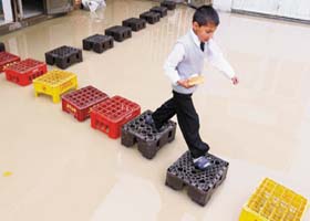 A child, holding a bread, walks on crates on a flooded street in the Bosa neighbourhood in Bogota