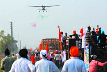 An aircraft showering confetti over the nagar kirtan taken out to mark the 541st birth anniversary of Guru Nanak Dev, the first Sikh guru, at Mallan village in Muktsar district on Friday. 