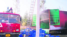 Firemen douse flames from the truck that caught fire at Kurli village near Lalru.