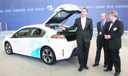 US President Barack Obama gestures as he talks about the Opel Ampera electric car as Opel VP Volker Hoff (R) and General Motors Portugal Managing Director Guillermo Sarmiento (C) look on at the NATO Summit in Lisbon