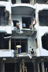 The municipal workers demolish an illegal building at Shkaurpur Basti in New Delhi on Saturday.