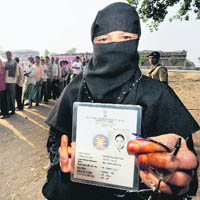 A Muslim woman shows her identity card after casting her vote during the final phase of Bihar Assembly polls in Sherghanti in Bodhgaya on Saturday.