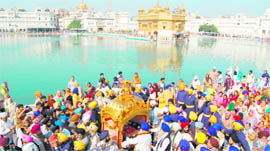 Devotees participate in a nagar kirtan procession held on the eve of Gurpurb at the Golden Temple on Saturday.