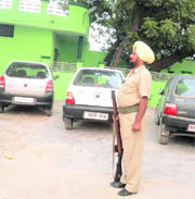 A policeman stands guard in the police station complex at Dirba which has a shrine located in it .