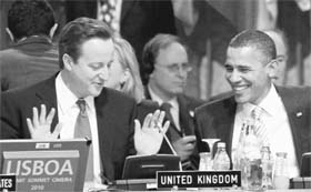 Britains PM David Cameron gestures during talks with US President Barack Obama at the NATO Summit in Lisbon
