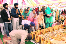Devotees pay obeisance before Guru Granth Sahib on the birth anniversary of Guru Nanak Dev in Dehradun on Sunday