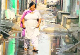 A woman walks through sewer water in the MC Colony at Sirsa