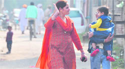 A woman tries to stop a child from sobbing as they quickly leave the tension-gripped Moti Nagar area in Ludhiana. 