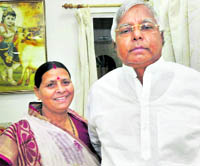 RJD chief Lalu Prasad with his wife Rabri Devi before a press conference at their residence in Patna on Sunday