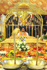 Granthi Ravel Singh sits behind Guru Granth Sahib as a Jalau, a splendour show of Sikhisms symbolic items, is displayed inside the Golden Temple on Sunday. The display took place on the occasion of the birth anniversary of Guru Nanak Dev.