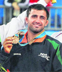 Sunil Kumar Rana poses with his bornze medal at the men's greco-roman 66-kilogram wrestling finals on Sunday.