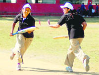 Two players cross over for a run in the Inter-Departmental Cricket Tournament for Women in Dehradun on Tuesday. 