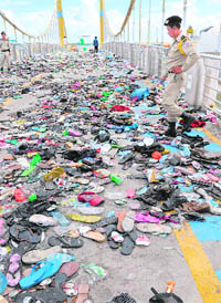 Cambodian police officials examine belongings of victims who were killed in a stampede on a bridge in Phnom Penh on Tuesday. As many as 378 people were killed and scores injured.