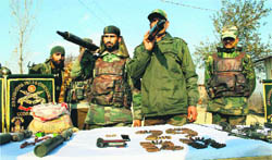 Army personnel display missiles and other arms and ammunition recovered from a hideout at Pattan near Srinagar