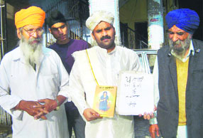 Pandit Rao Dharennavar at a gurdwara in Yamunanagar with a copy of the Punjabi version of Kannada book Akka Mahadevi A Tribune photograph