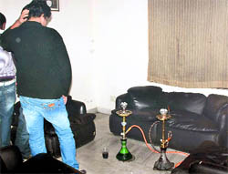 A youth tries to hide his identity after the hookah joint was raided