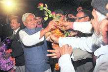Bihar Chief Minister Nitish Kumar receives flowers from supporters during celebrations after NDAs win in Bihar Assembly poll, in Patna on Wednesday. 