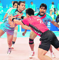 Eom Tae-deok (C) of South Korea tries to avoid a tackle by Indian players during their group A match on Wednesday. India beat South Korea 37-19
